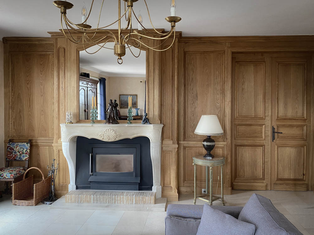 Agencement salon de style classique avec boiseries, cheminé et lustre