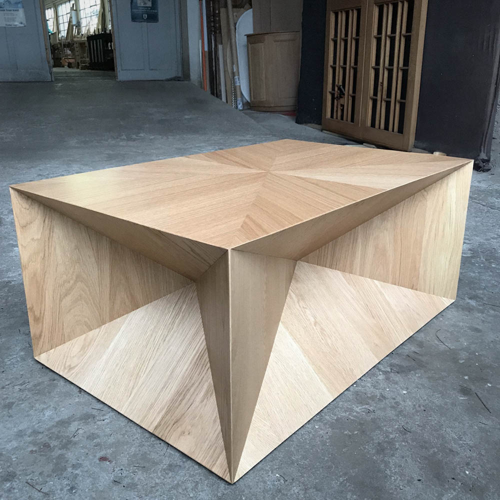 Dans un atelier, un cube de présentation design en bois clair