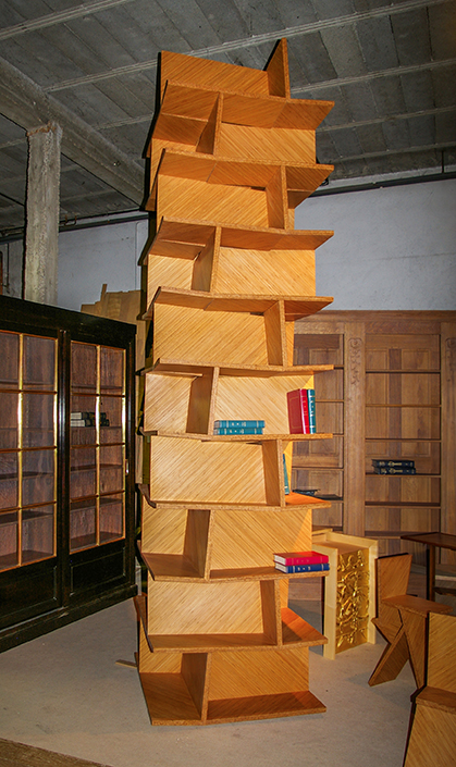 Dans un atelier une bibliothèque haute en bois et déstructurée